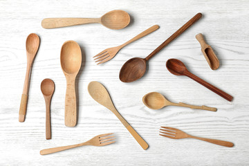 Flat lay composition with wooden cutlery on white wooden table