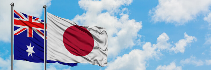 Australia and Japan flag waving in the wind against white cloudy blue sky together. Diplomacy concept, international relations.