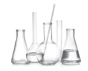 Laboratory glassware with liquid samples on white background