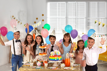 Happy children at birthday party in decorated room