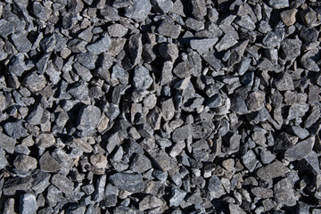 Cracked asphalt background.Black textured view.Road construction materials.Urban style.Black stones.