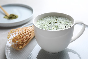 Tasty matcha green tea latte on light grey table, closeup