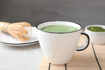 Tasty matcha green tea latte on light grey marble table, closeup