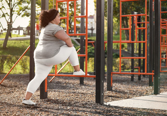 Fototapeta premium Beautiful overweight woman training on sports ground