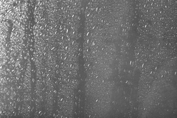 Naklejka na ściany i meble Glass with rain drops against light background
