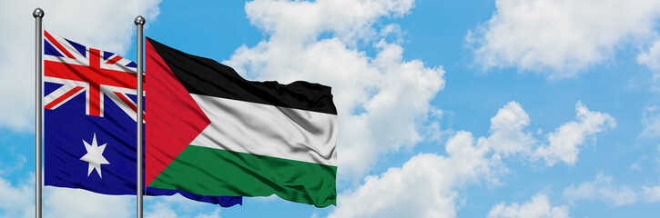Australia and Palestine flag waving in the wind against white cloudy blue sky together. Diplomacy concept, international relations.