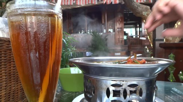 a hot soup of fish from west sumatra, indonesia. its very hot , even the spoon are burned .
