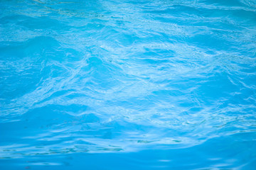 Fototapeta na wymiar Surface of blue swimming pool background of water in swimming pool. Simulate natural wave ocean water texture summer or abstract blue sea water with white foam for copy space, nature concept.