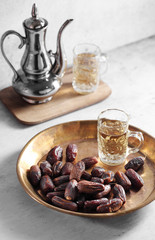 dates fruit and Arab tea on a white concrete background with a blank space for a text, dates fruit on a white background