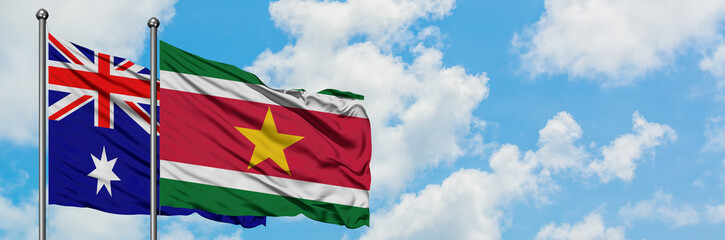 Obraz premium Australia and Suriname flag waving in the wind against white cloudy blue sky together. Diplomacy concept, international relations.