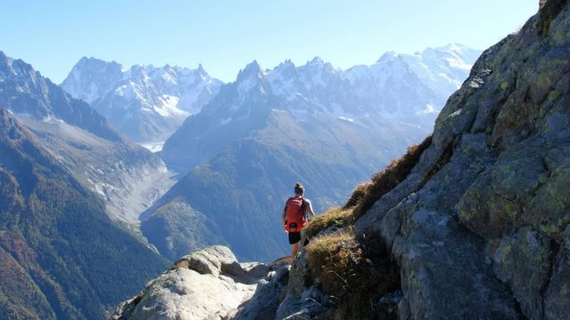 Cha&icirc;ne du Mont Blanc view from the Aiguilles Rouge, near Chamonix. An amazing hike to do. Tacul Geant Glacier in the back. Girl walking alone on the trail, descending from the Lac Blanc.