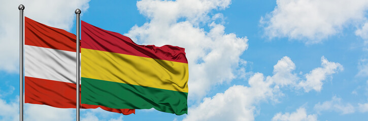 Fototapeta na wymiar Austria and Bolivia flag waving in the wind against white cloudy blue sky together. Diplomacy concept, international relations.