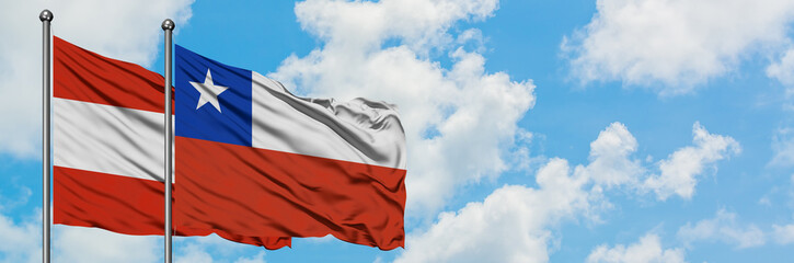 Austria and Chile flag waving in the wind against white cloudy blue sky together. Diplomacy concept, international relations.