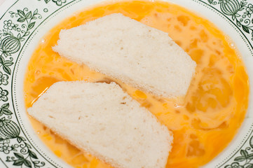 Soaking the cut bread in the egg mixture. Salvation of old bread from stale and flowering. Cooking croutons from bread and chicken eggs.