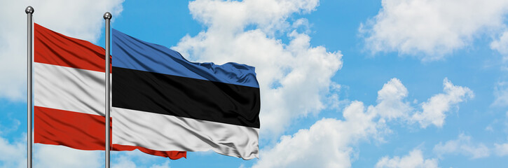 Austria and Estonia flag waving in the wind against white cloudy blue sky together. Diplomacy concept, international relations.