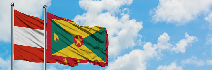 Austria and Grenada flag waving in the wind against white cloudy blue sky together. Diplomacy concept, international relations.