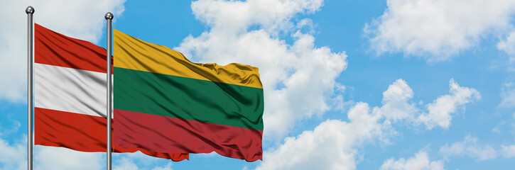 Obraz premium Austria and Lithuania flag waving in the wind against white cloudy blue sky together. Diplomacy concept, international relations.