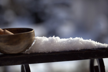 Tibetan singing bowl with its hammer on balustrade, close-up. - winter Image
