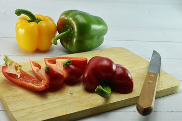 Closeup  fresh  Red, Yellow, Green, bell pepper or sweet pepper or capsicum  isolate slice on  chopping wood on white background ,raw food ingredient concept.