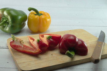 Closeup  fresh  Red, Yellow, Green, bell pepper or sweet pepper or capsicum  isolate slice on  chopping wood on white background ,raw food ingredient concept.