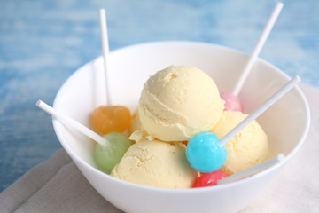 vanilla ice cream and candy on a blue background with a blank space for a text, vanilla ice cream in white ceramic cup
