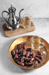 dates fruit and Arab tea on a white concrete background with a blank space for a text, dates fruit on a white background