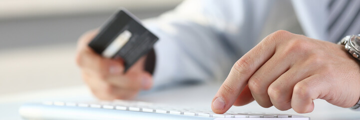 Male arms hold credit card press buttons
