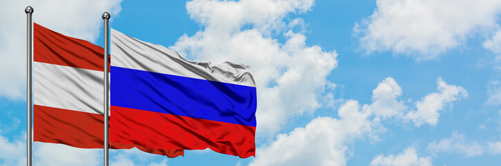 Austria and Russia flag waving in the wind against white cloudy blue sky together. Diplomacy concept, international relations.