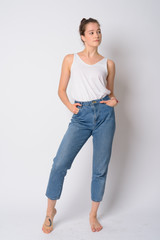 Full body shot of young beautiful woman standing and thinking