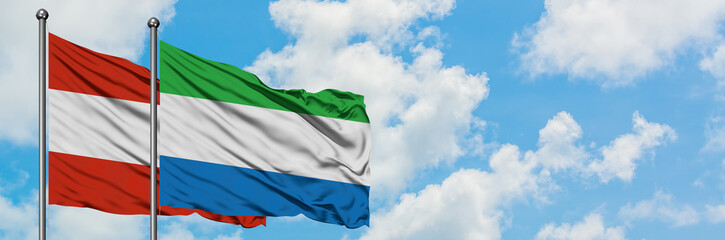 Austria and Sierra Leone flag waving in the wind against white cloudy blue sky together. Diplomacy concept, international relations.