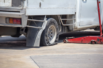 Flat tire changing with wheel wrench,  waiting for repair. Car flat tire change at garage service shop.