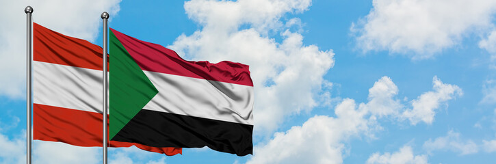 Fototapeta na wymiar Austria and Sudan flag waving in the wind against white cloudy blue sky together. Diplomacy concept, international relations.