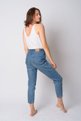 Full body shot profile view of young beautiful woman looking over shoulder