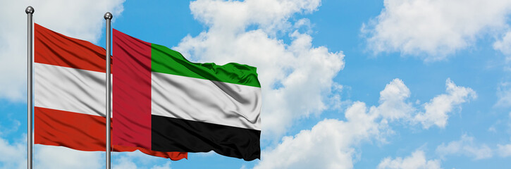 Fototapeta na wymiar Austria and United Arab Emirates flag waving in the wind against white cloudy blue sky together. Diplomacy concept, international relations.