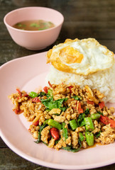 Stir fried chicken with holy basil leaves served with fried egg and steamed rice