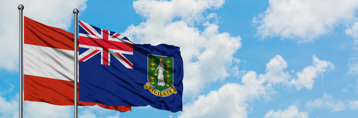 Fototapeta premium Austria and British Virgin Islands flag waving in the wind against white cloudy blue sky together. Diplomacy concept, international relations.