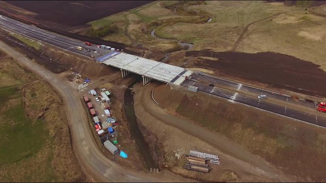 Drone flies over the construction of a new bridge over a small river
