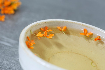 cup of hot tea with osmanthus flower, aromatic relaxation drink