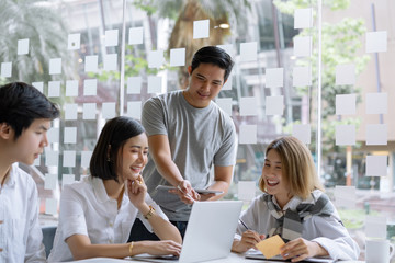 Young creative startup business team discussing work together in modern start up office.