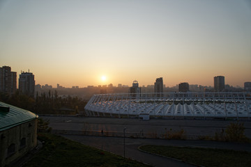 Stadium construction. Aerial view of the stadium roof on the city's background. Sunset behind stadium for soccer