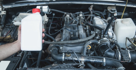 Plastic bottle of machine oil with a car motor.