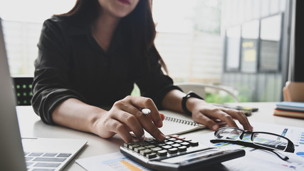 Cropped shot young businesswoman calculate finance data on calculator.