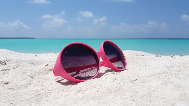 Abstract concept, pink sunglasses on tropical beach with white sand in Malaysia
