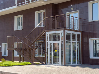 Glass vestibule entrance to a residential building. The theme of an emerging housing market under construction