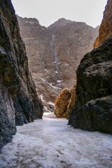 Fototapeta na wymiar Bottom of the Yolyn Am or Yoliin Am canyon ice field in spring, Gobi Gurvansaikhan National Park. Gobi desert, Mongolia.