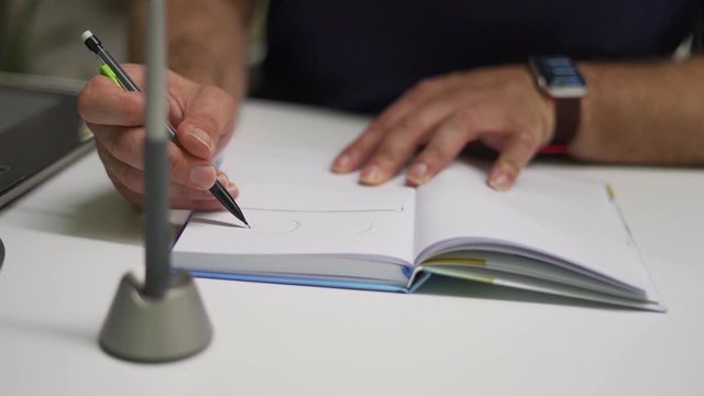 Graphic designer sketching in notebook