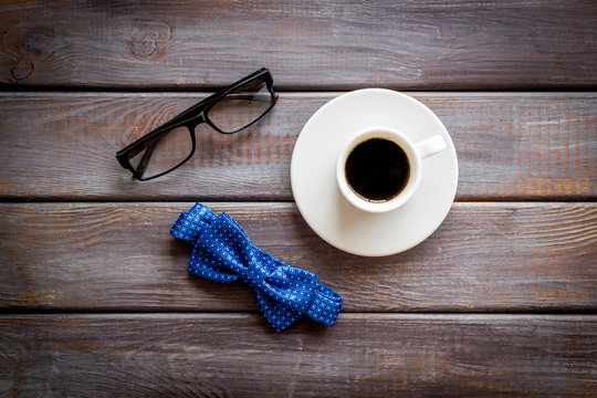 Father's Day or men's birthday concept. Bow tie, glasses and coffee on dark wooden background top view
