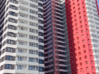Fototapeta premium Red, black and white facades of new high-rise residential buildings. The theme of an emerging housing market under construction
