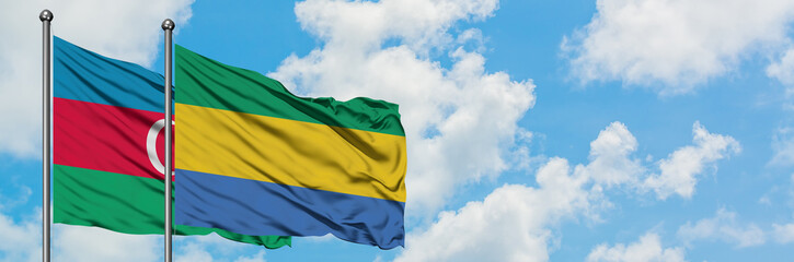 Azerbaijan and Gabon flag waving in the wind against white cloudy blue sky together. Diplomacy...