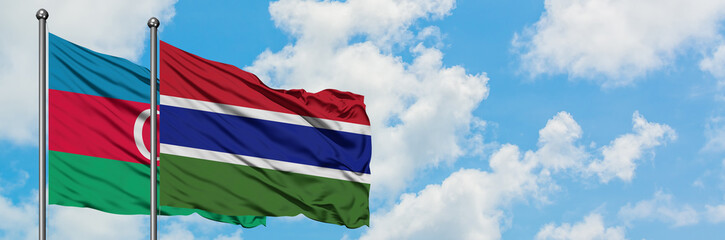 Azerbaijan and Gambia flag waving in the wind against white cloudy blue sky together. Diplomacy concept, international relations.